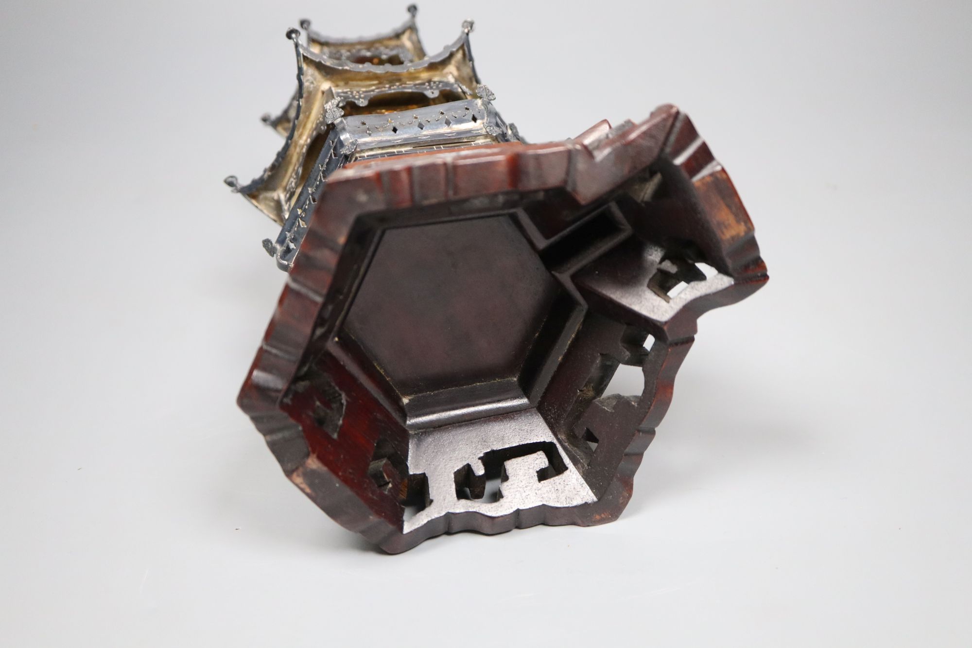 An early 20th century Chinese white metal miniature model of a pagoda, on a hardwood base, model 21.4cm, 11.5oz,